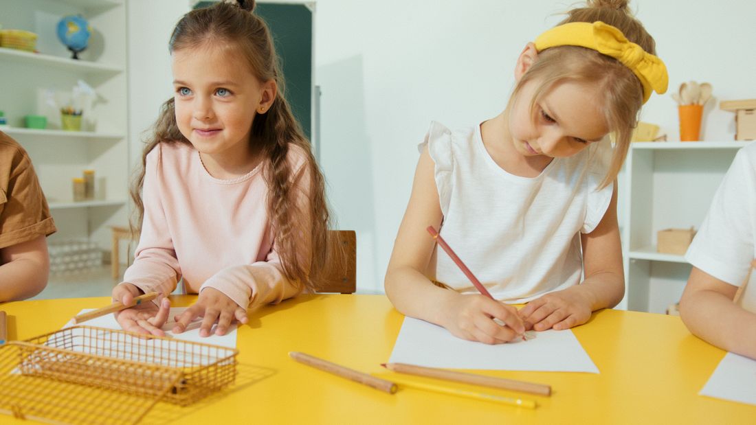 Preschool children drawing together at a classroom table